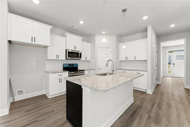 a kitchen with a sink a microwave a refrigerator and cabinets