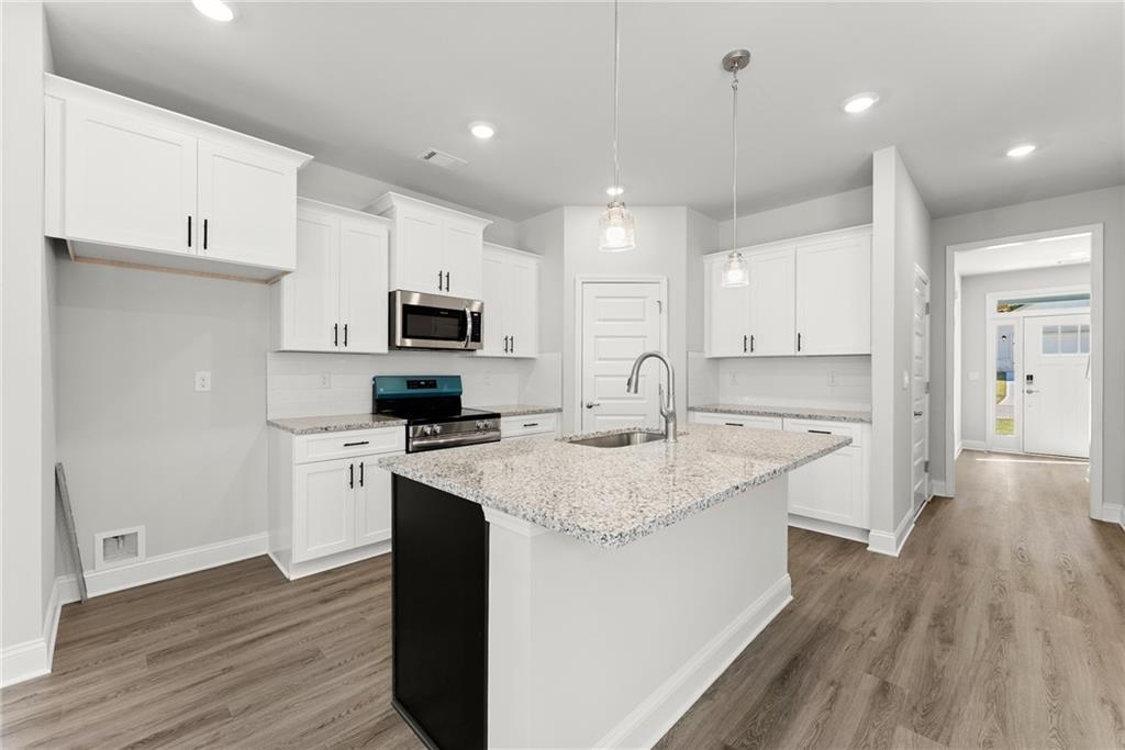 285 Magnolia Villas Drive Cornelia, GA 30531 - Photo 9 of 49 a kitchen with a sink a microwave a refrigerator and cabinets