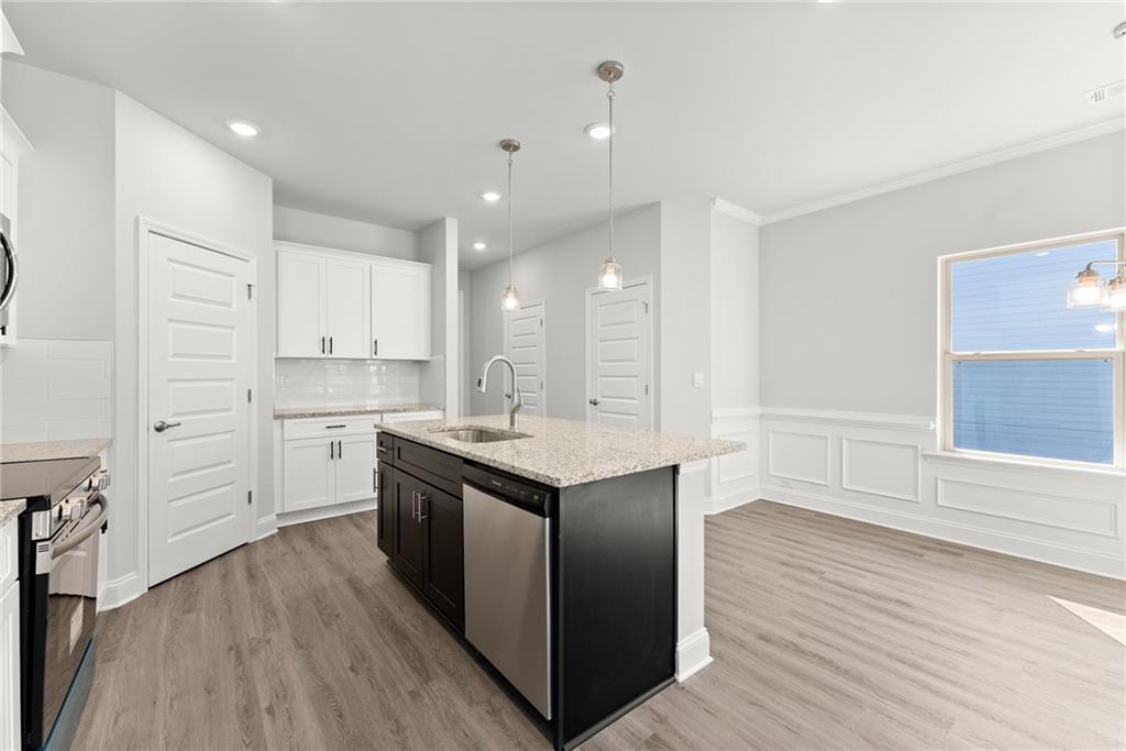 285 Magnolia Villas Drive Cornelia, GA 30531 - Photo 10 of 49 a kitchen with stainless steel appliances granite countertop a white cabinets and wooden floor