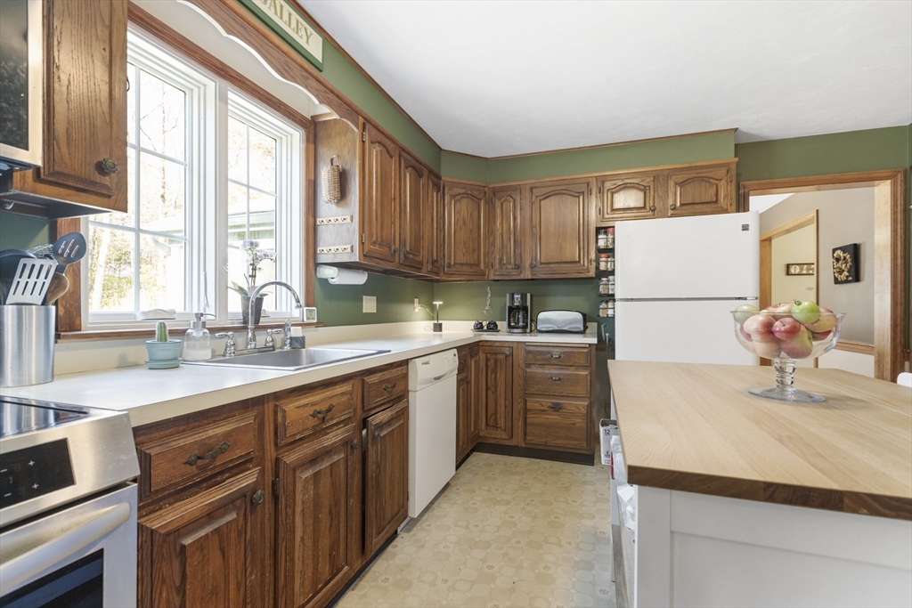103 Uxbridge Street Douglas, MA 01569 - Photo 12 of 38 a kitchen with kitchen island granite countertop a sink appliances cabinets and a large window