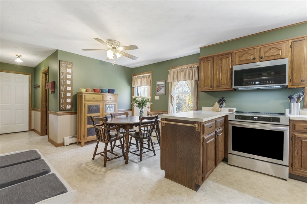 103 Uxbridge Street Douglas, MA 01569 - Photo 14 of 38 a kitchen with stainless steel appliances granite countertop a stove top oven a sink dishwasher and a refrigerator with wooden cabinets