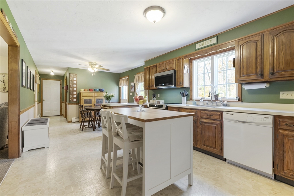 103 Uxbridge Street Douglas, MA 01569 - Photo 16 of 38 a kitchen with stainless steel appliances granite countertop a stove top oven a sink dishwasher a refrigerator and cabinets with wooden floor