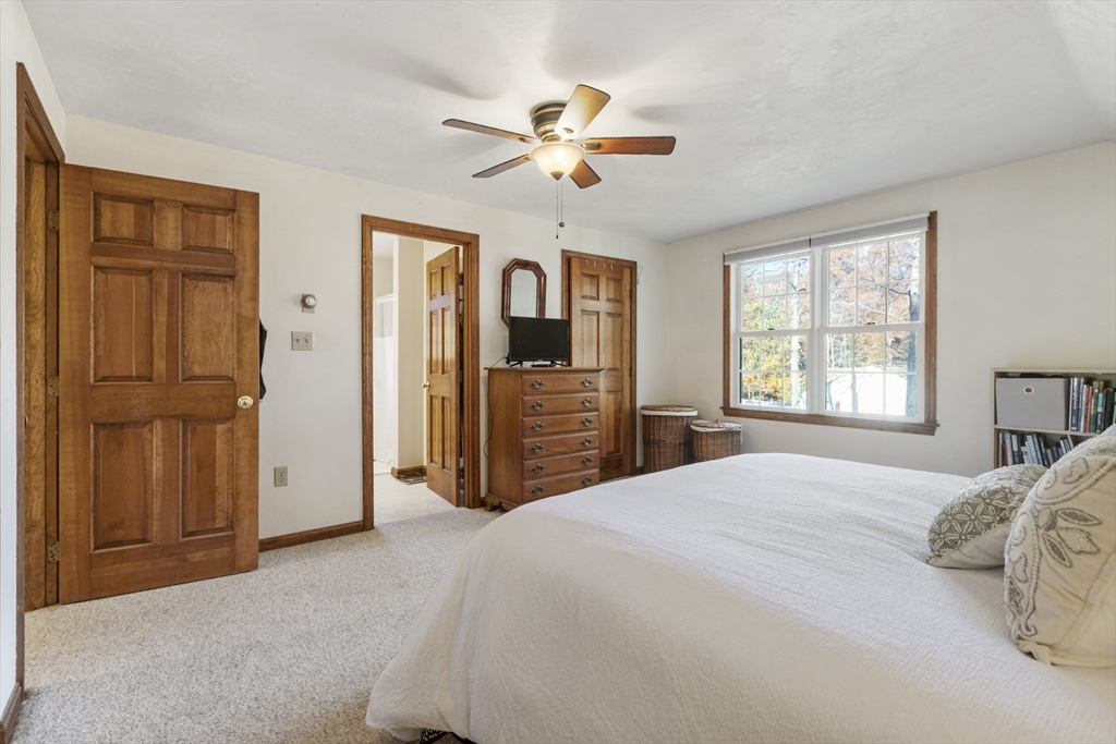 103 Uxbridge Street Douglas, MA 01569 - Photo 35 of 38 a bedroom with a large bed a chandelier and closet