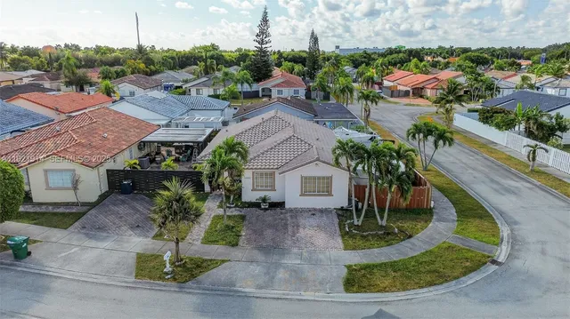 an aerial view of a house with a yard and potted plants