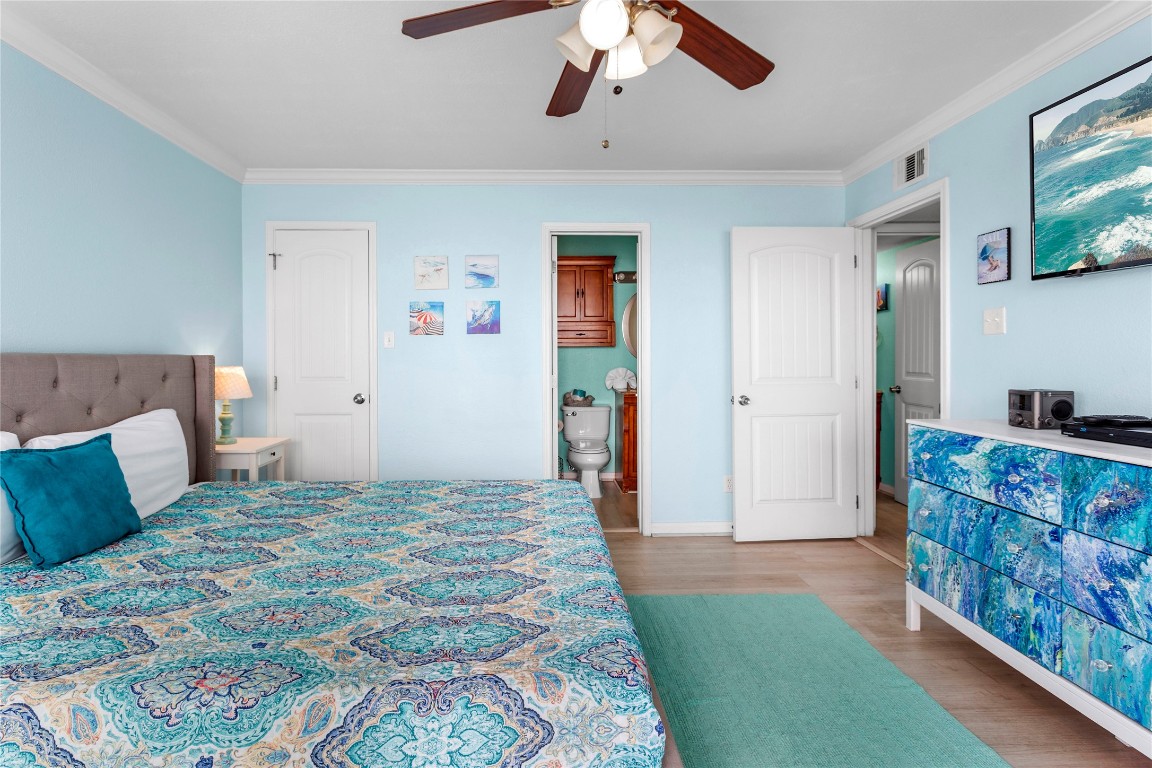 10811 Termini-San Luis Pass Road, Unit 1307 Galveston, TX 77554 - Photo 15 of 28 a bedroom with a bed and a chandelier