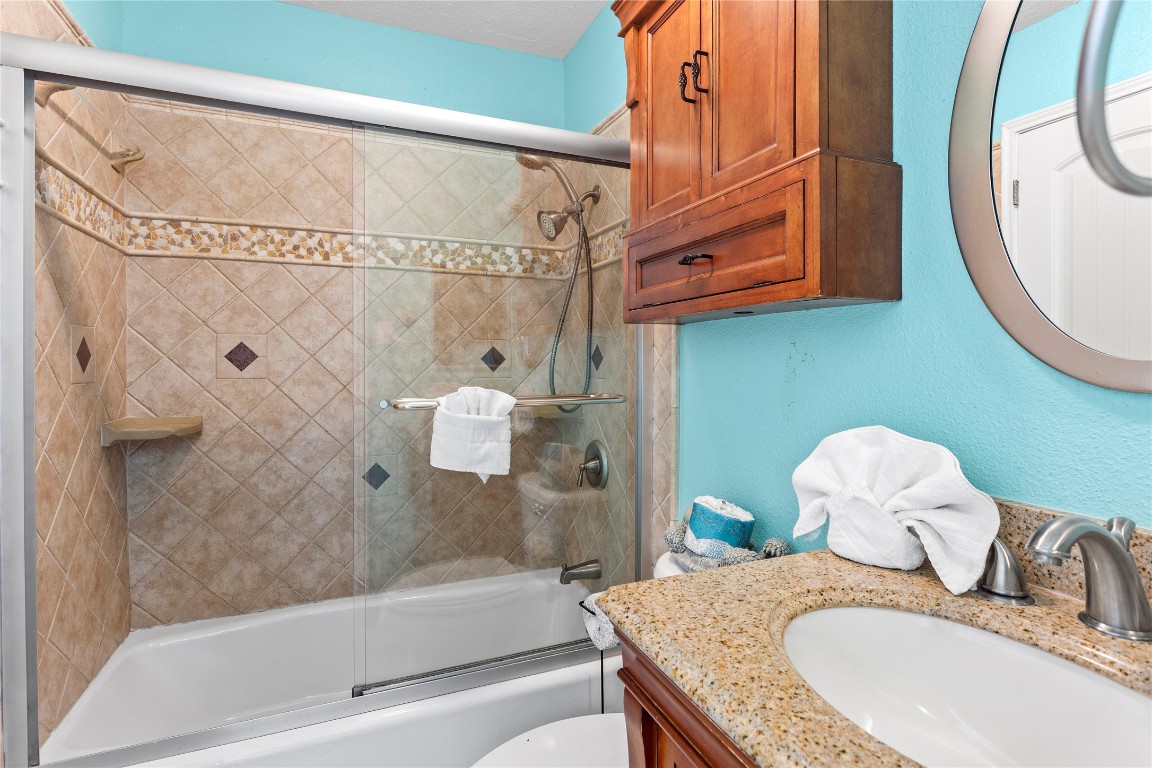 10811 Termini-San Luis Pass Road, Unit 1307 Galveston, TX 77554 - Photo 17 of 28 a bathroom with a granite countertop sink and a mirror