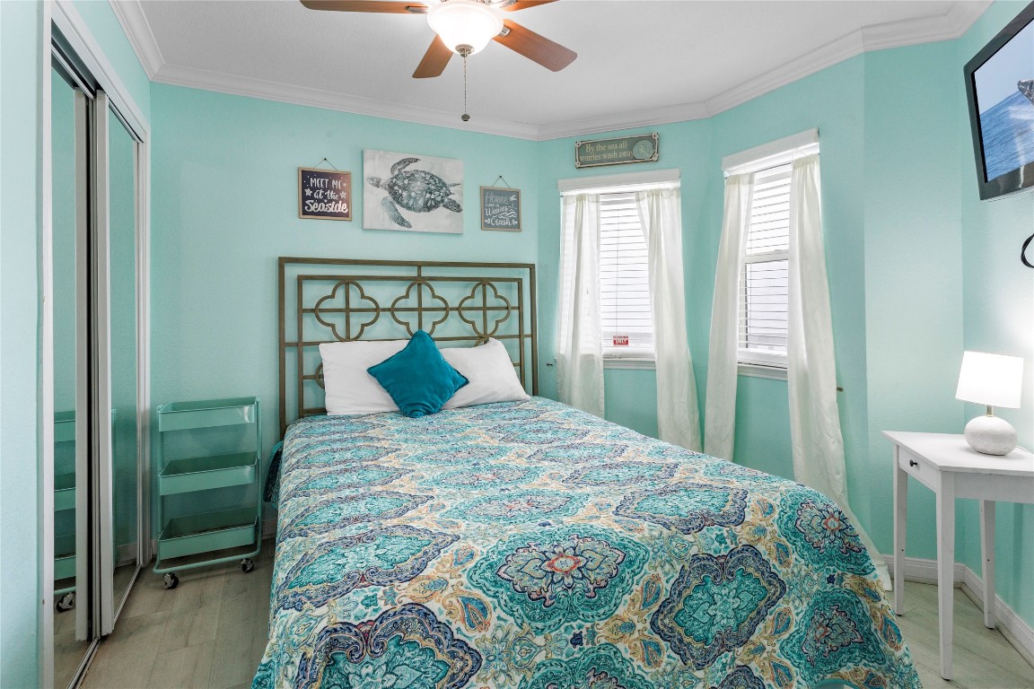 10811 Termini-San Luis Pass Road, Unit 1307 Galveston, TX 77554 - Photo 18 of 28 a large bed sitting in a bedroom next to a window and a chandelier