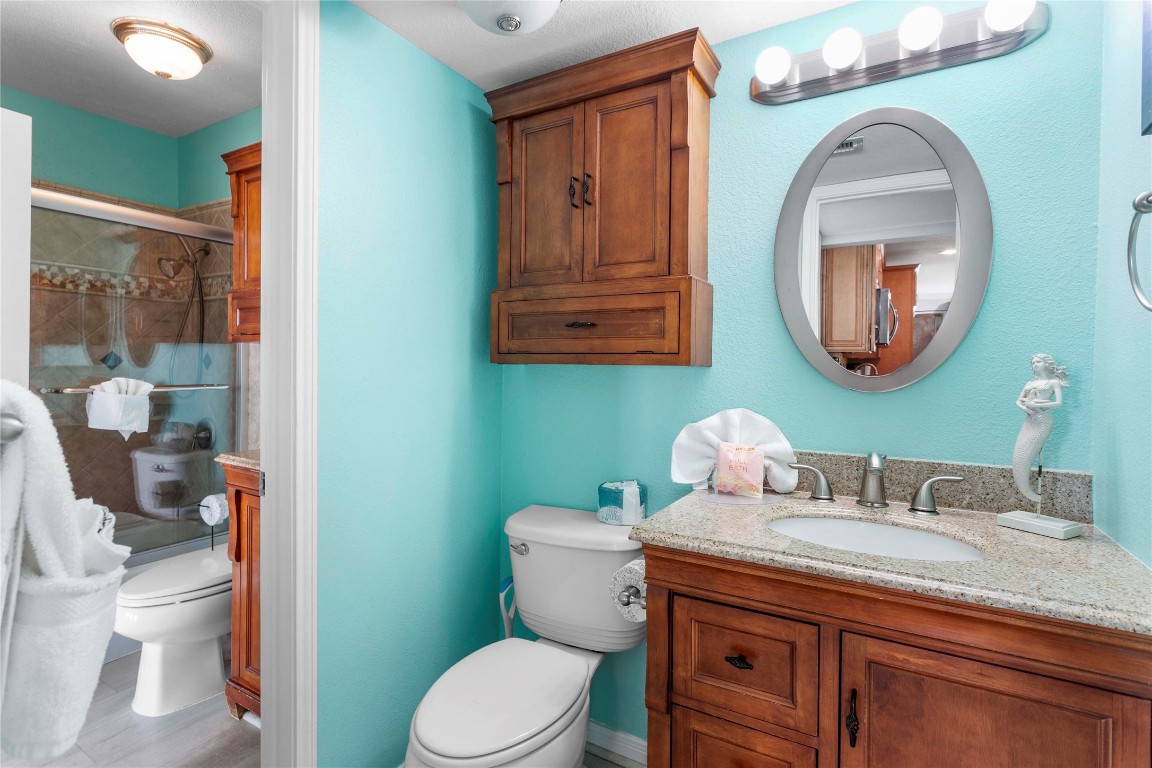 10811 Termini-San Luis Pass Road, Unit 1307 Galveston, TX 77554 - Photo 20 of 28 a bathroom with a toilet a sink and a mirror