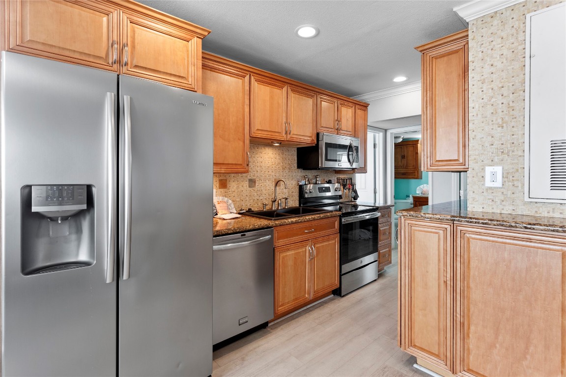 10811 Termini-San Luis Pass Road, Unit 1307 Galveston, TX 77554 - Photo 9 of 28 a kitchen with stainless steel appliances granite countertop a refrigerator a stove a sink and a window