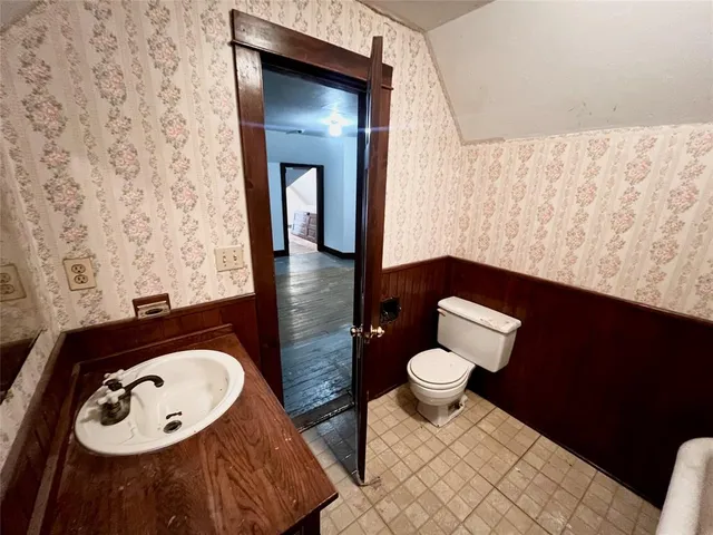 an empty room with wooden floor and entrance