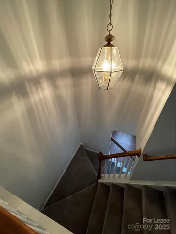a view of a hallway with wooden floor and stairs