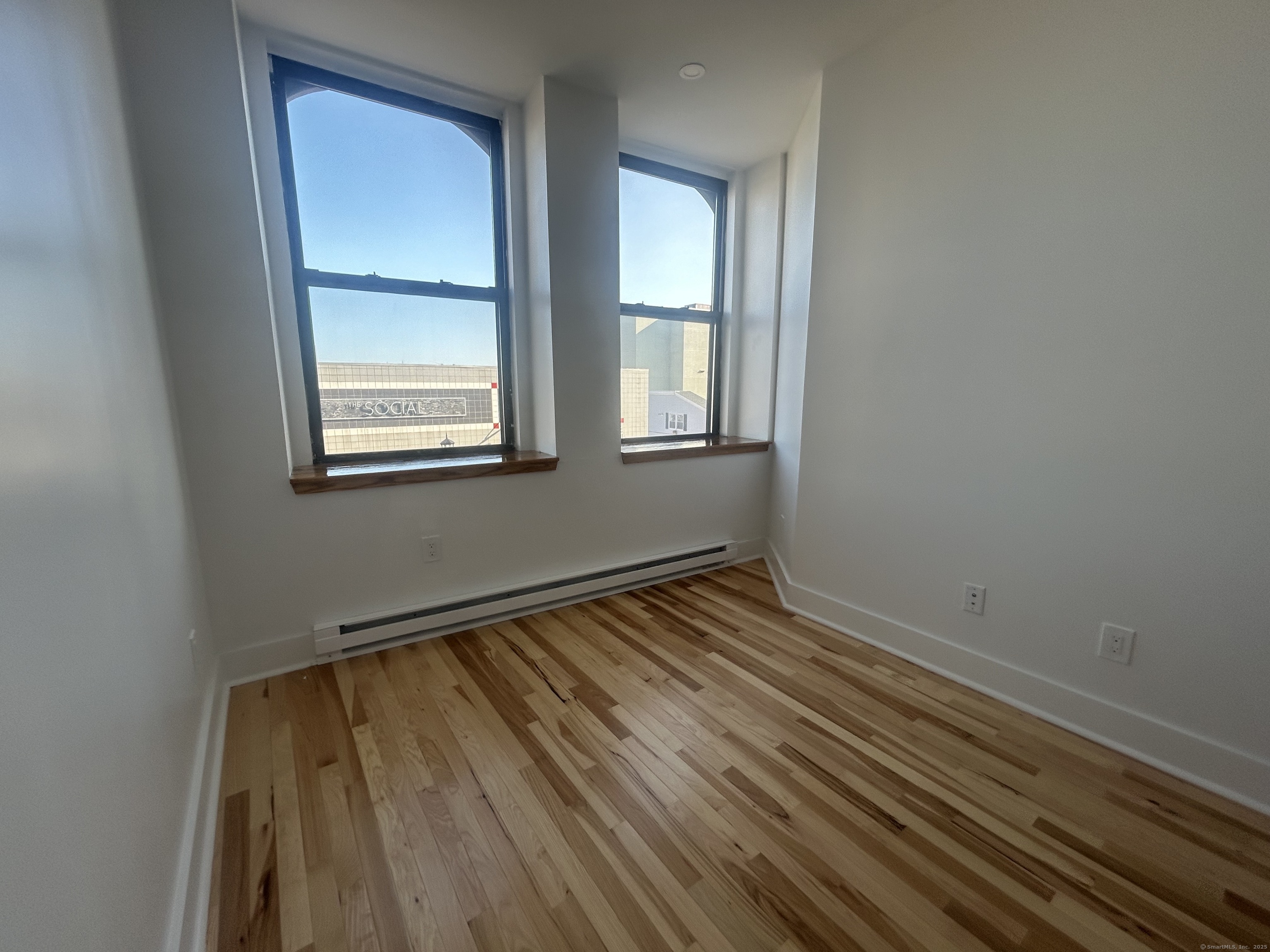 207 Bank Street, Unit 201 New London, CT 06320 - Photo 6 of 12 an empty room with wooden floor and windows