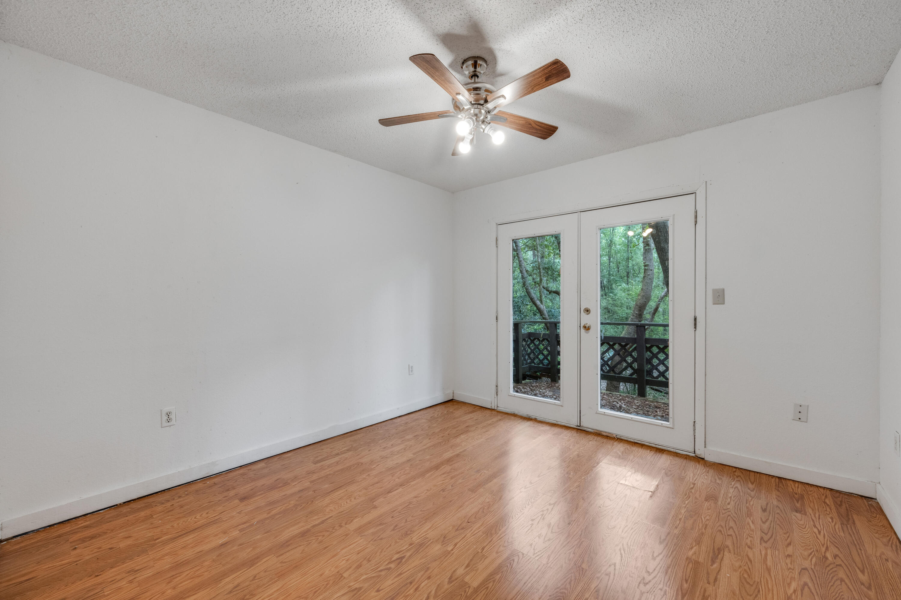 4157 Sundance Way Holt, FL 32564 - Photo 4 of 30 an empty room with wooden floor fan and windows