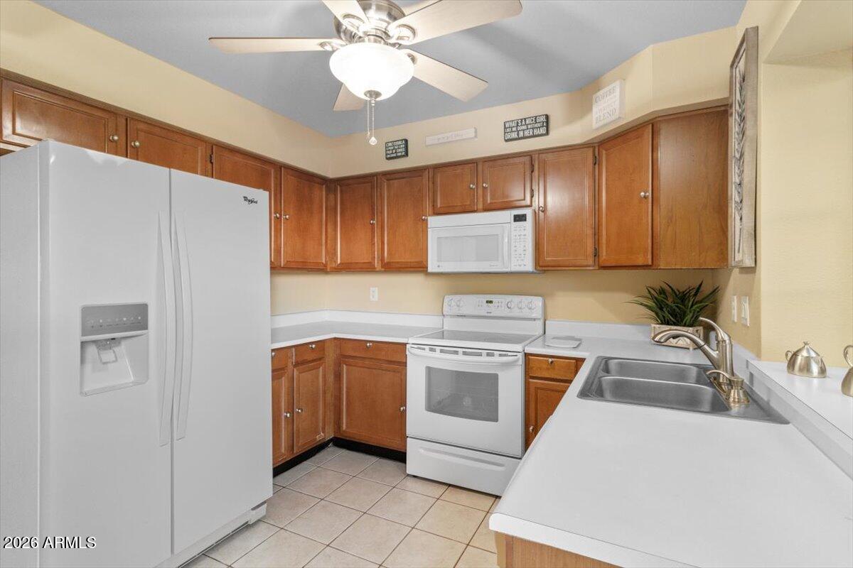 7905 West Thunderbird Road, Unit 285 Peoria, AZ 85381 - Photo 7 of 27 a kitchen with stainless steel appliances granite countertop a sink stove and refrigerator