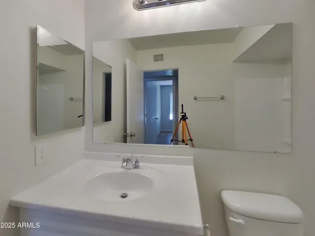 a bathroom with a sink a toilet and mirror