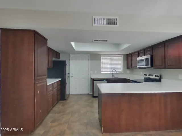a kitchen with stainless steel appliances granite countertop a sink stove and refrigerator