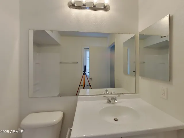 a bathroom with a sink a toilet and a mirror