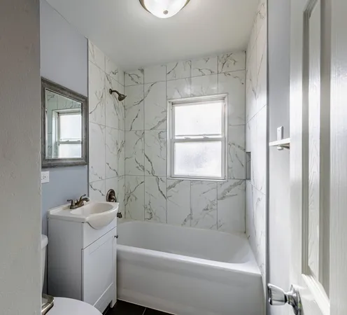 a bathroom with a bathtub a window and a shower