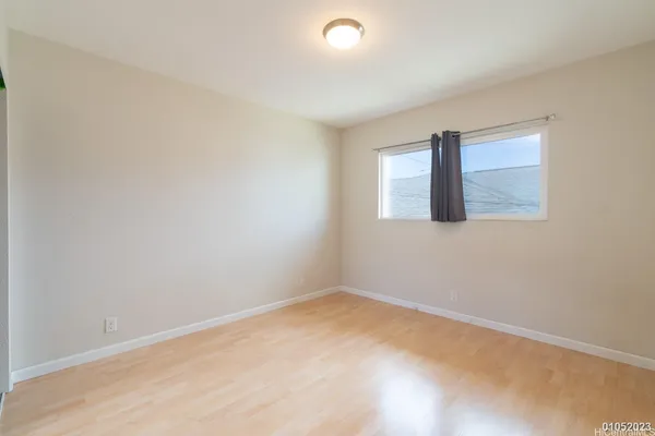an empty room with sliding glass door and mirror