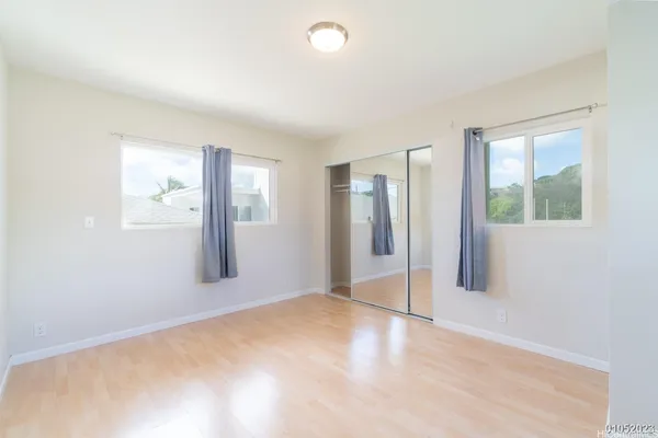 an empty room with windows and closet
