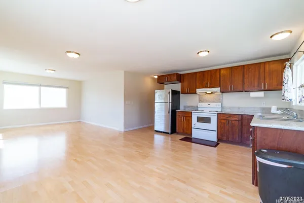 a kitchen with stainless steel appliances kitchen island granite countertop a stove a sink and a refrigerator