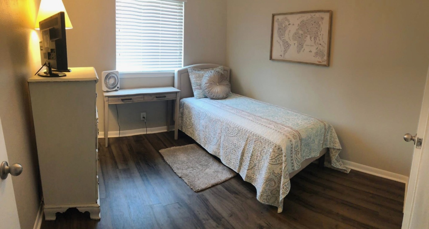 2401 Manor Road, Unit 117 Austin, TX 78722 - Photo 4 of 7 a bedroom with a bed and wooden floor