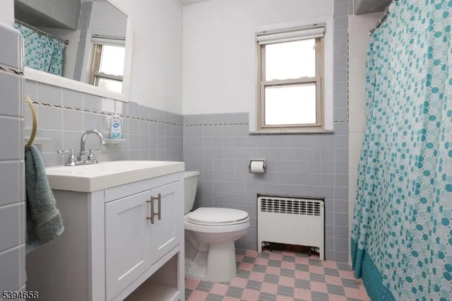 a bathroom with a sink toilet and window