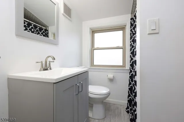 a bathroom with a sink a toilet and window