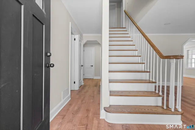 a view of entryway with wooden floor and stairs