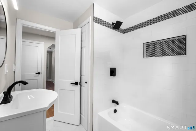 a bathroom with a sink a shower and a mirror