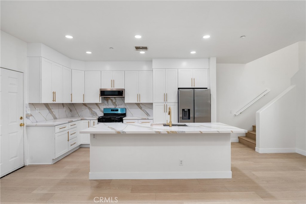 312 Quail Ridge Irvine, CA 92603 - Photo 10 of 20 a large kitchen with stainless steel appliances granite countertop a stove a sink and a refrigerator