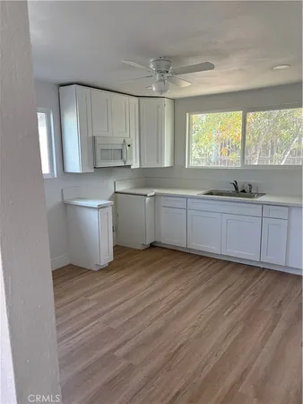 a large kitchen with kitchen island white cabinets and wooden floor