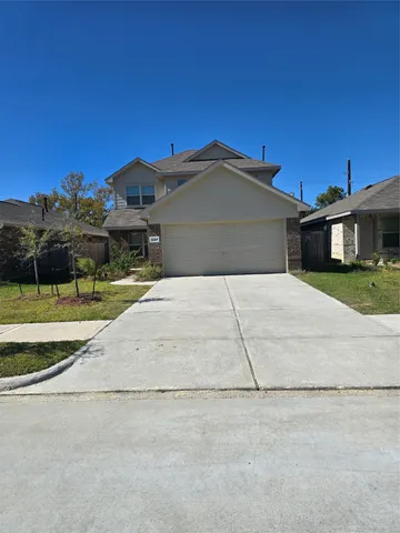 a front view of a house with a yard and potted plants
