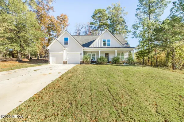 a front view of a house with a yard and trees
