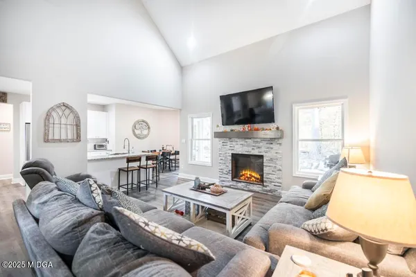 a living room with furniture a fireplace and a flat screen tv