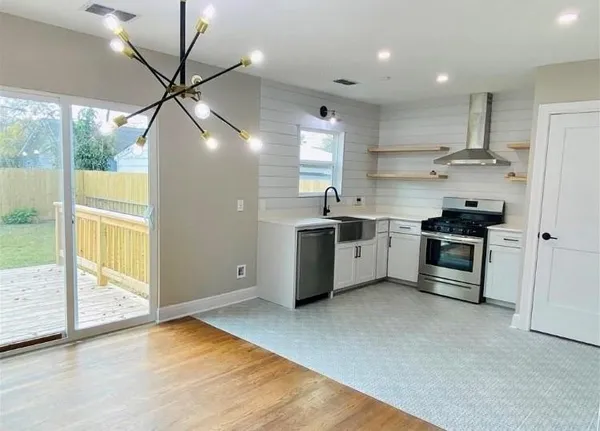 a kitchen with stainless steel appliances a stove a sink and a refrigerator