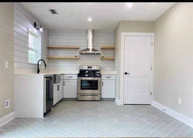 a kitchen with stainless steel appliances a white stove top oven and sink