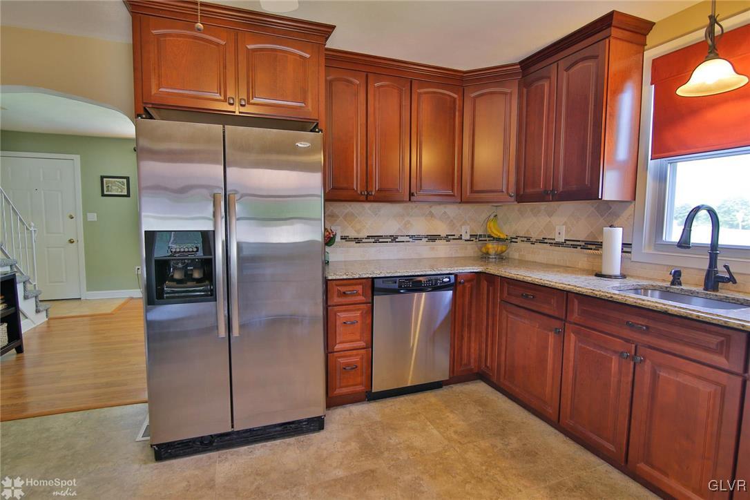 538 School Road Nazareth, PA 18064 - Photo 11 of 29 a kitchen with stainless steel appliances granite countertop a refrigerator a sink a stove with wooden cabinets