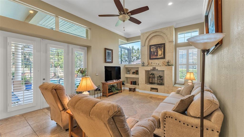237 McLean Point Winter Haven, FL 33884 - Photo 38 of 85 a living room with furniture a fireplace and a floor to ceiling window
