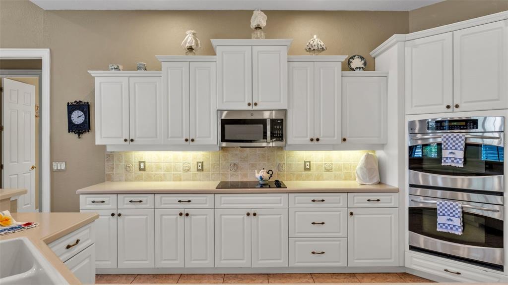 237 McLean Point Winter Haven, FL 33884 - Photo 45 of 85 a kitchen with white cabinets and stainless steel appliances