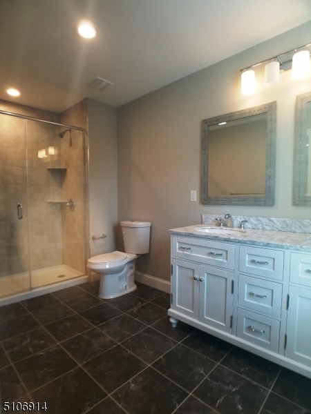 6 Elm Street, Unit 5 Madison, NJ 07940 - Photo 13 of 18 a bathroom with a double vanity sink mirror and toilet