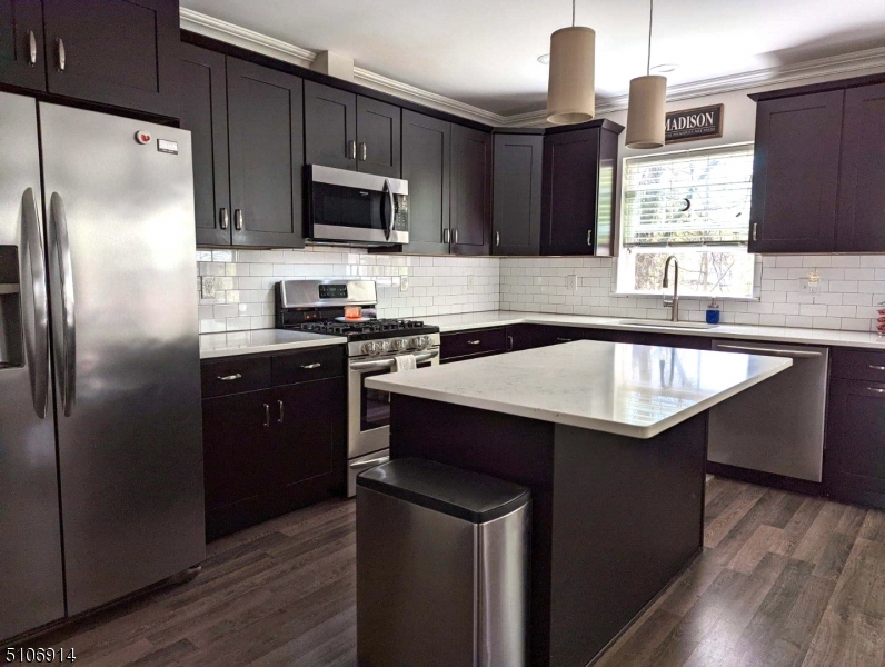 6 Elm Street, Unit 5 Madison, NJ 07940 - Photo 6 of 18 a kitchen with a sink a center island stainless steel appliances and cabinets