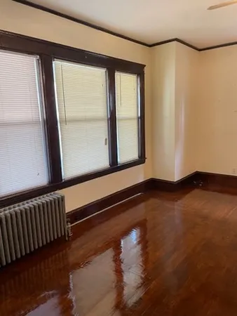 a living room with hard wood floors and a kitchen view