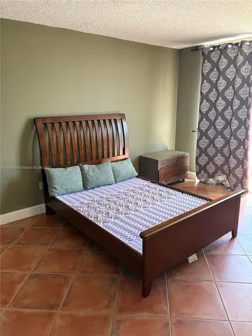 a bed sitting in a bedroom next to a window