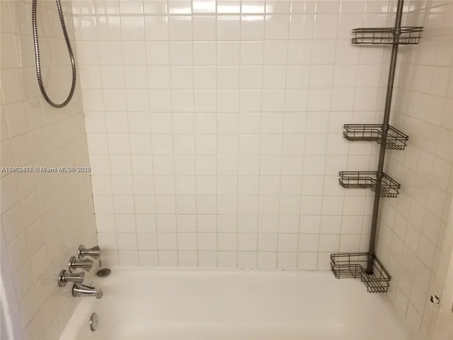 a bathroom with a bath tub with a shower