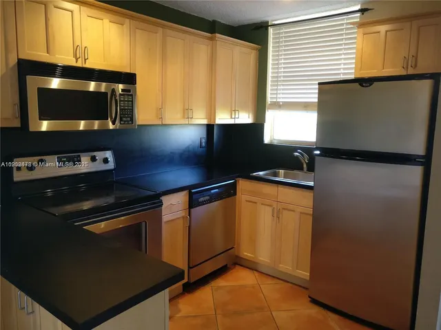 a kitchen with stainless steel appliances a stove refrigerator and microwave