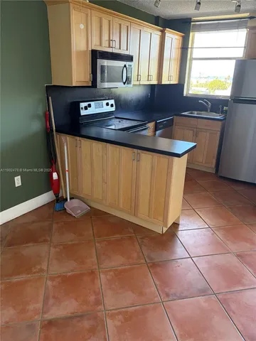 a kitchen with a sink a counter and cabinets