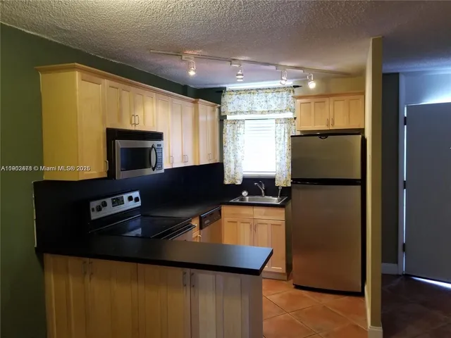a kitchen with stainless steel appliances a refrigerator stove and microwave