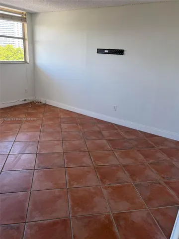 a view of a room with an empty space and a window