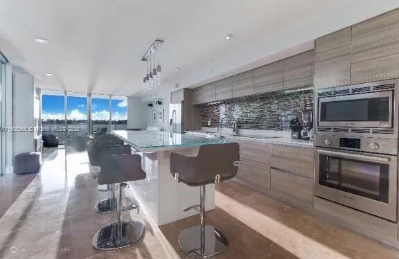 a kitchen with stainless steel appliances granite countertop a stove a sink a microwave and a refrigerator